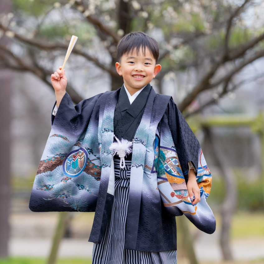 5歳男の子が七五三の袴を着て右手を上げている写真